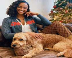 The star is accompanied by a big dog in her home.